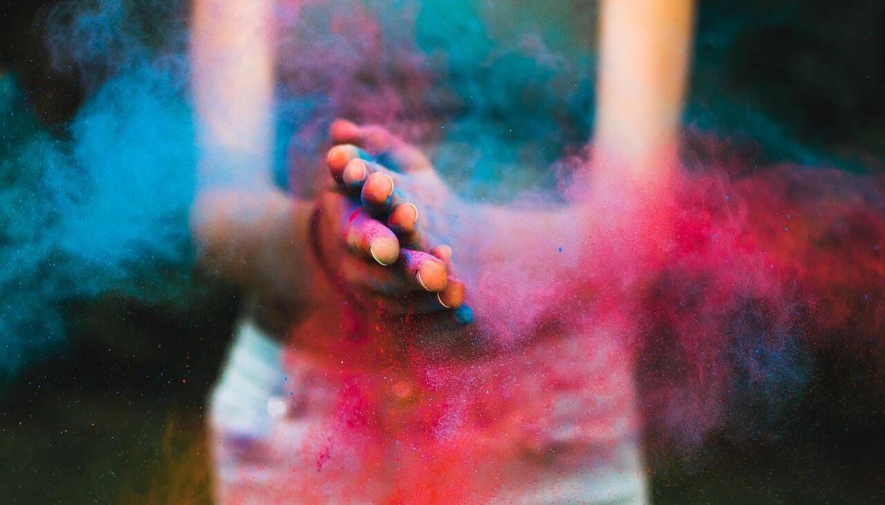 Woman spreading color powder with her hands.