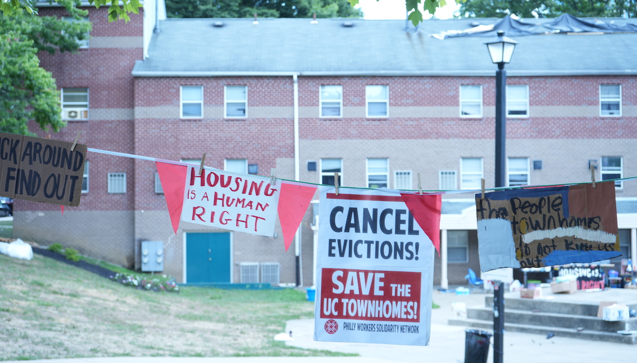 Pictured: a hanged banner that reads "Cancel Evictions! Save UC Townhomes"