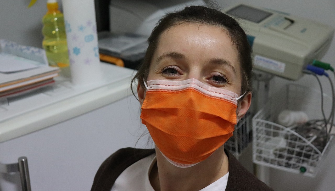 Nurse wearing a mask smiles. 
