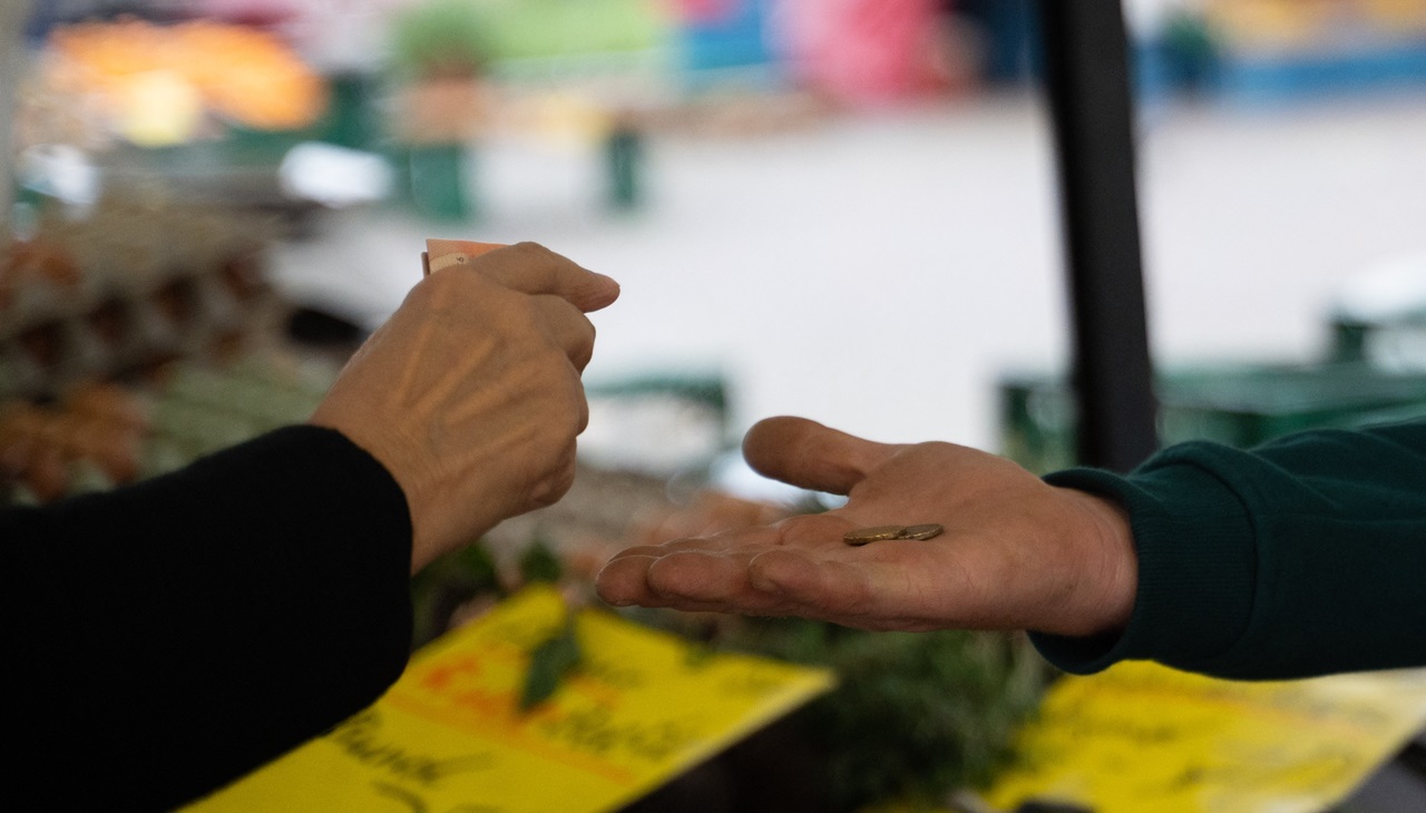 Bremen: Una mujer paga sus verduras a un vendedor en el mercado semanal. Foto: Alicia Windzio/dpa (Foto de Alicia Windzio / DPA / dpa Picture-Alliance vía AFP)