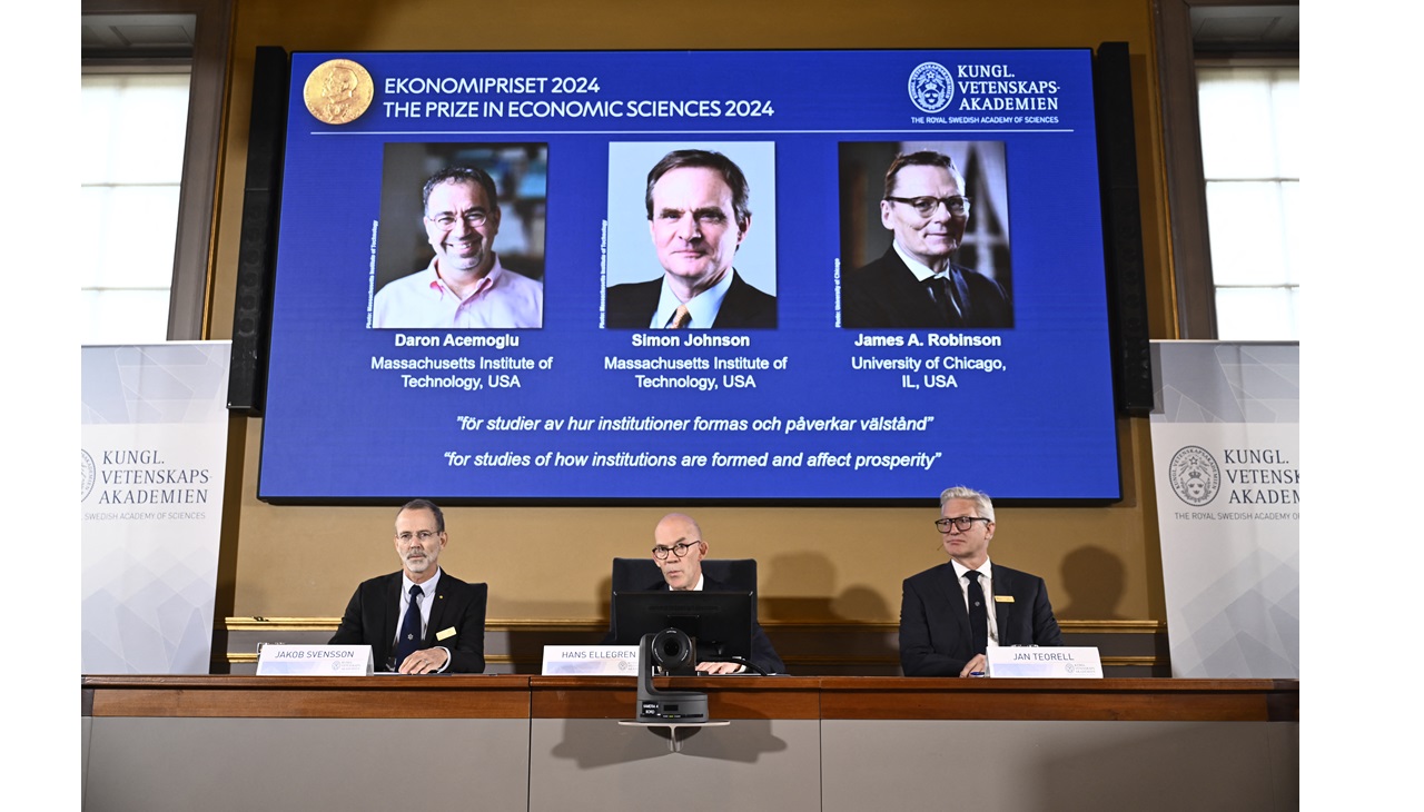 El secretario permanente de la Academia de las Ciencias, Hans Ellegren (C), Jakob Svensson (I) y Jan Teorell, de la Asamblea Nobel, anuncian a los galardonados (I-D), Daron Acemoglu, Simon Johnson y James Robinson. Foto de Christine Olsson/TT / AGENCIA DE NOTICIAS TT / AFP