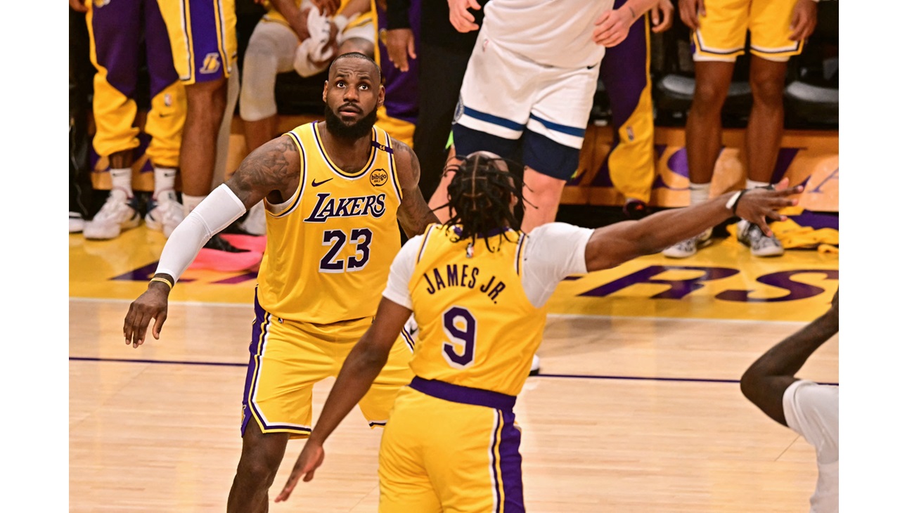 Lebron James, and his son in a basketball match. (Photo by Frederic J. Brown / AFP)