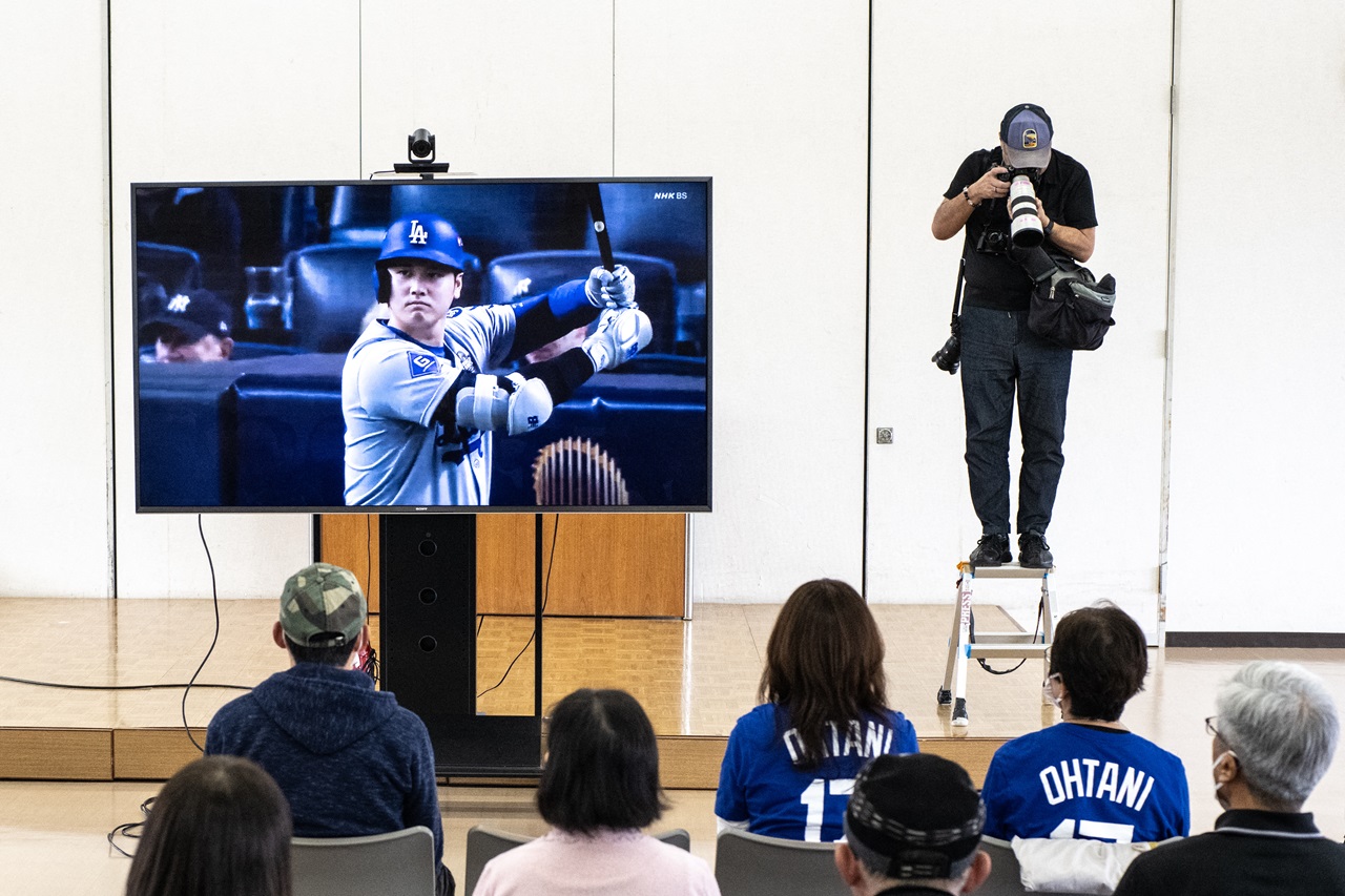 Un grupo de personas asiste a un acto público para ver el partido de las Series Mundiales de béisbol entre los Dodgers de Los Ángeles y los Yankees de Nueva York en Oshu, en la prefectura de Iwate, ciudad natal de la superestrella de los Dodgers Shohei Ohtani (en la pantalla de televisión), el 30 de octubre de 2024. (Foto de Philip FONG / AFP)