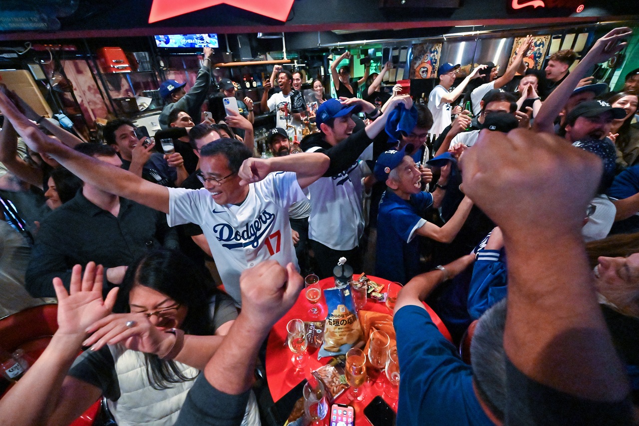 Dodgers fans cheer as their team wins Game 5 of the US Major League Baseball World Series against the New York Yankees in New York to take the best-of-seven championship 4-1. (Photo by Richard A. Brooks / AFP)