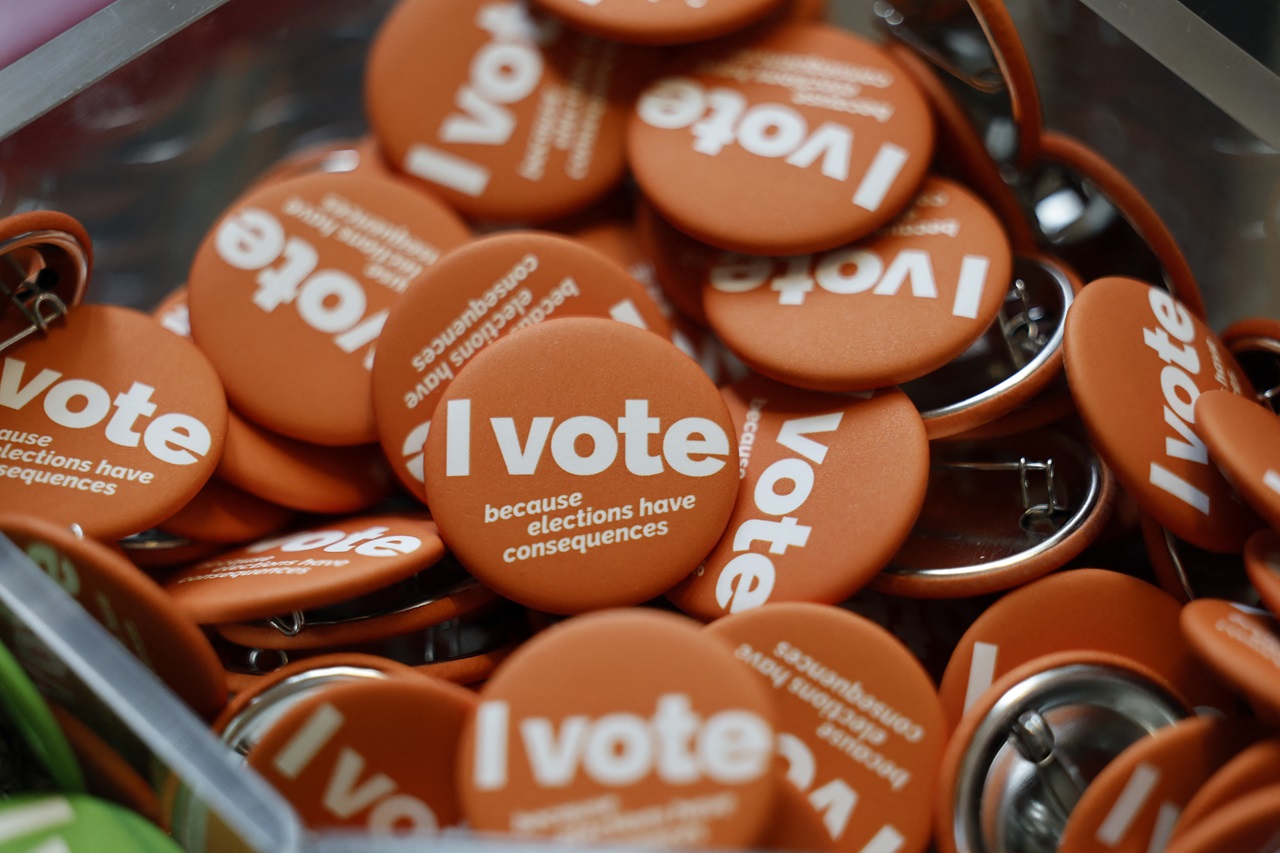 Buttons being handed out during early voting for the general election at the University of Michigan Museum of Art Gallery in Ann Arbor, Michigan on October 31, 2024. Kamala Harris clapped back Thursday at Donald Trump over what she called his "very offensive" remarks about women, returning reproductive rights to the fore as the rivals took their knife-edge White House race to western battleground states. (Photo by JEFF KOWALSKY / AFP)