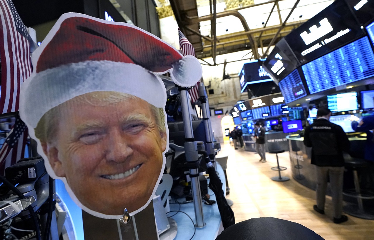 An image of US President-elect Donald Trump is displayed as traders and financial professionals work on the floor of the New York Stock Exchange (NYSE) at the opening bell on November 26, 2024, in New York City. (Photo by TIMOTHY A. CLARY / AFP)