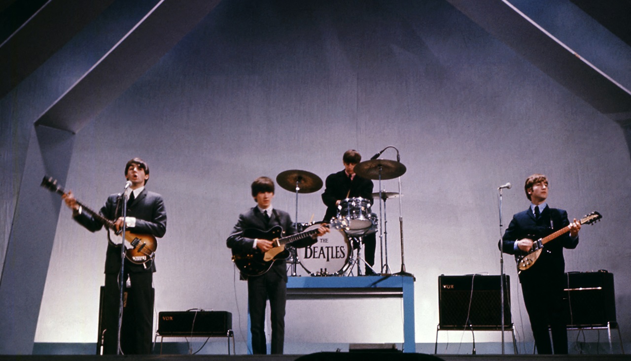 El grupo inglés The Beatles (de izquierda a derecha), Paul McCartney (bajo), George Harrison (guitarra), Ringo Starr (batería) y John Lennon (guitarra) actúan en el escenario durante un concierto, el 29 de julio de 1965, en Londres. (Foto de CENTRAL PRESS / AFP)