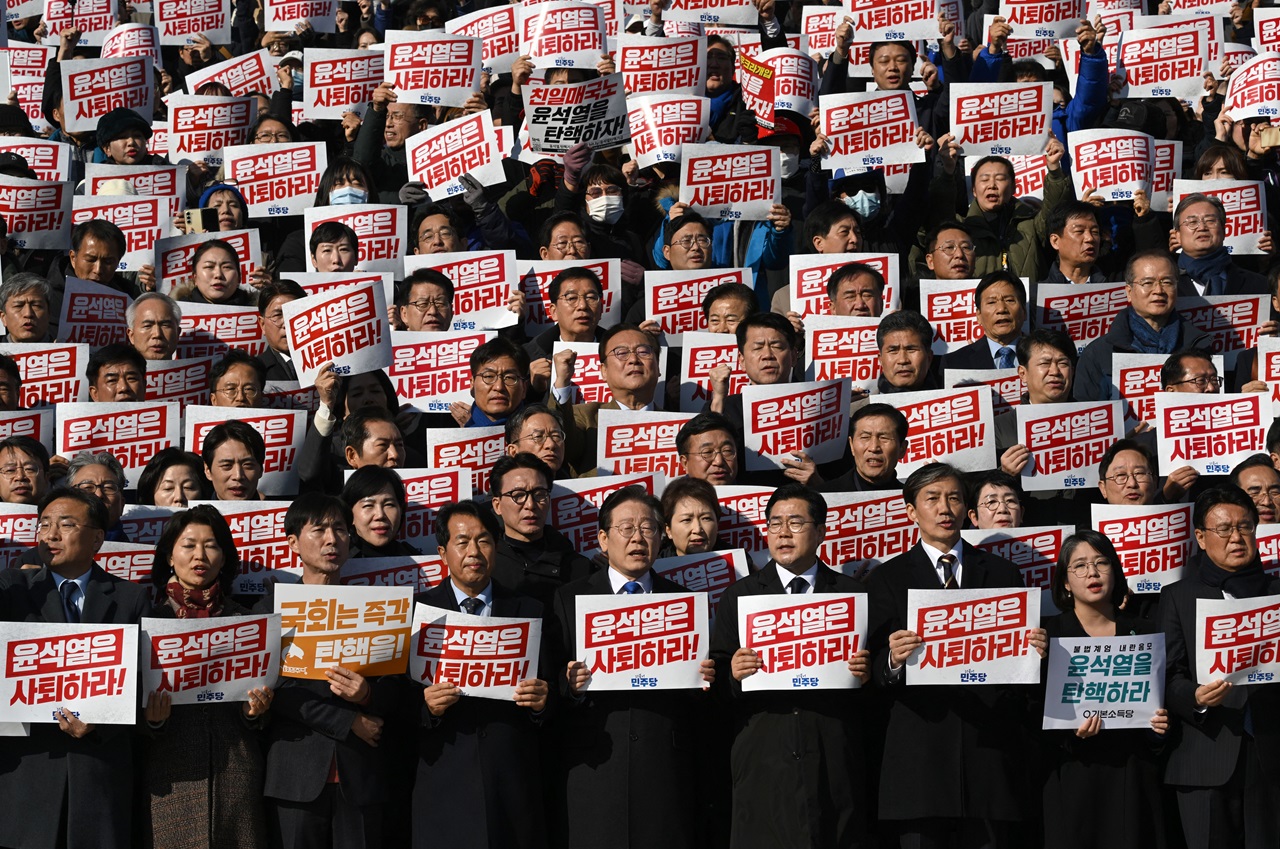 Lawmakers and South Korea's main opposition Democratic Party members hold placards reading "Yoon Suk Yeol should resign!", today. (Photo by Jung Yeon-je / AFP)