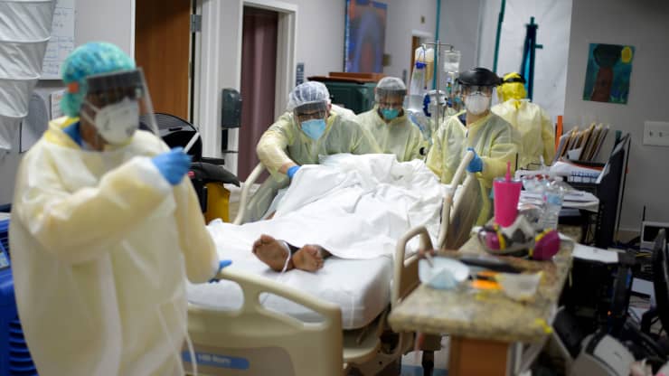 Healthcare workers move a patient in the COVID-19 Unit at United Memorial Medical Center. Photo Credit: Mark Felix | Getty Images