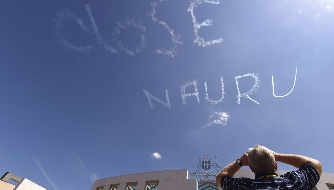  A man watches a sky-writing reading 'CLOSE NAURU' above Parliament House in Canberra, Australia, 17 February 2015. The protest was put together by three individuals calling themselves 'Unaligned Individuals'. Nauru and Manus island, in northern Papua New Guinea, is used by Australia as an immigration detention and asylum seeker processing centre, where illegal migrants are kept for long times. EPA/MICK TSIKAS AUSTRALIA AND NEW ZEALAND OUT