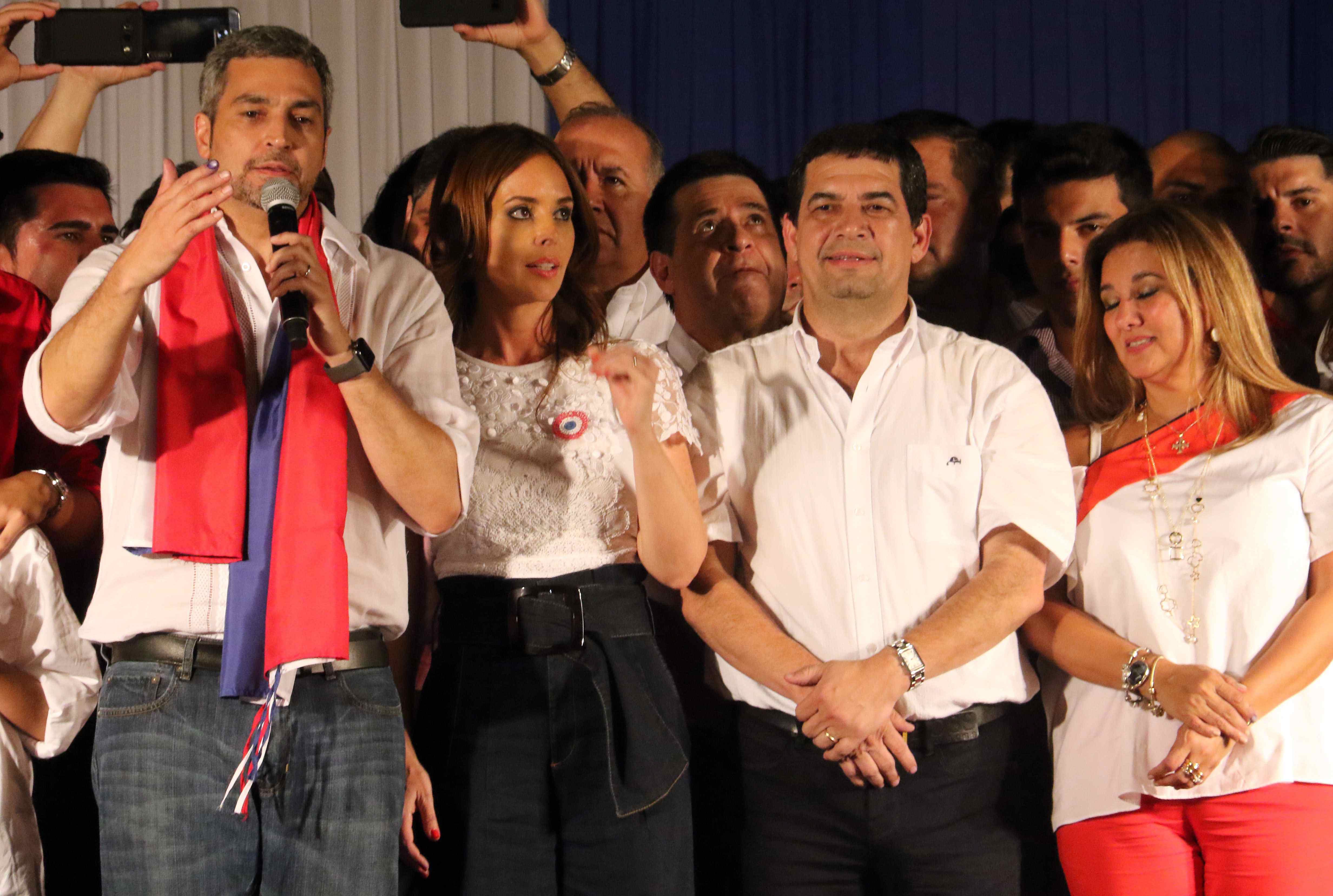 Candidate of the ruling Colorado Party Mario Abdo Benitez (L) speaks, accompanied by his wife Silvana Lopez (2-L), his candidate to the vice presidency Hugo Velazquez (2-R) and Lourdes Samaniego (R), wife of Velazquez, in front of the headquarters of the Colorado Party in Asuncion, Paraguay, Apr. 22, 2018. EPA-EFE/ANDRES CRISTALDO
