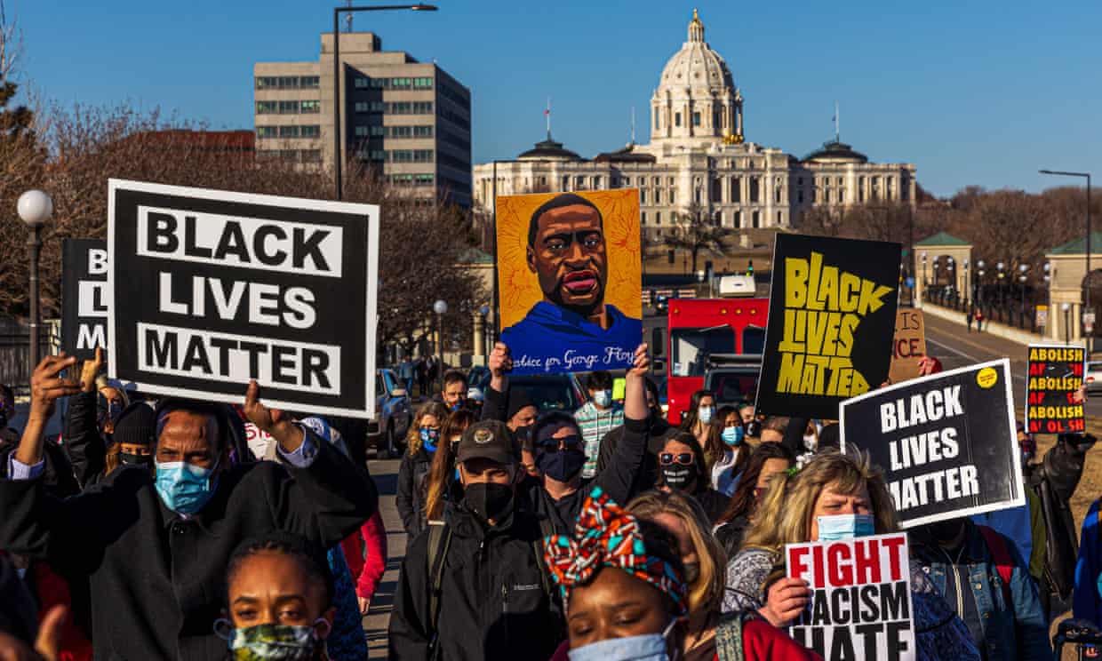 People hold signs during a ‘Justice for George Floyd’ march in Saint Paul, Minnesota, on 19 March. Photograph: Kerem Yucel/AFP/Getty Images