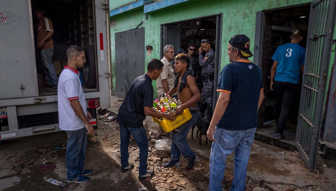  Un trabajador de una licorera que fue saqueada en horas de la madrugada en el sector La Vega saca productos del local comercial este jueves 28 de diciembre del 2017, en Caracas (Venezuela). Durante la madrugada de este jueves se registraron en varios puntos de Venezuelaprotestas por la escasez de alimentos para completar el menú navideño, gas y agua, informaron hoy medios locales. EFE/MIGUEL GUTIÉRREZ
