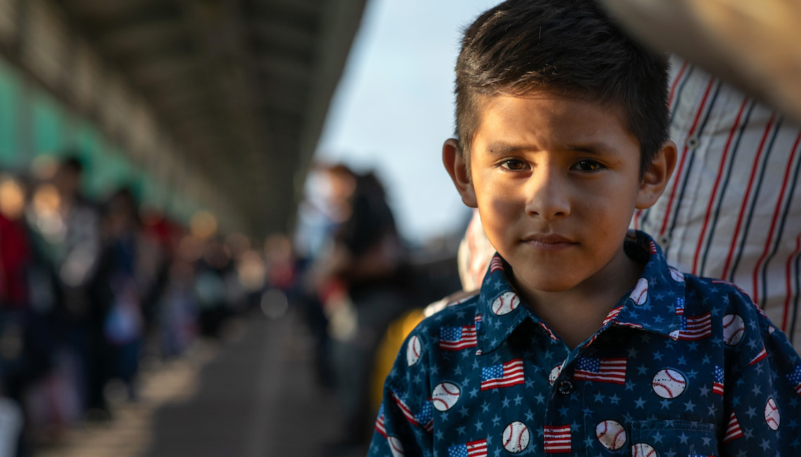 MATAMOROS, MÉXICO - DICIEMBRE 09: El solicitante de asilo hondureño, Christopher, de 6 años, está junto a su padre en el puente internacional de México a los Estados Unidos el 09 de diciembre de 2019 en la ciudad fronteriza de Matamoros, México. (Foto de John Moore/Getty Images)