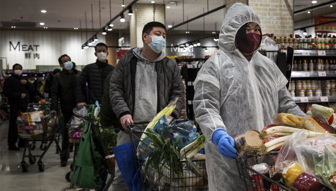 Residents wear protective masks as they line up in the supermarket on February 12, 2020 in Wuhan, Hubei province, China. Photo: Stringer/Getty Images.