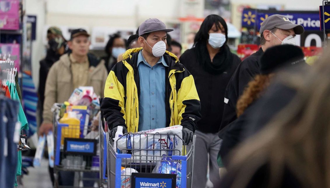 Las personas que usan máscaras y guantes esperan para pagar en Walmart el 03 de abril de 2020, en Uniondale, Nueva York. Al Bello/Getty Images