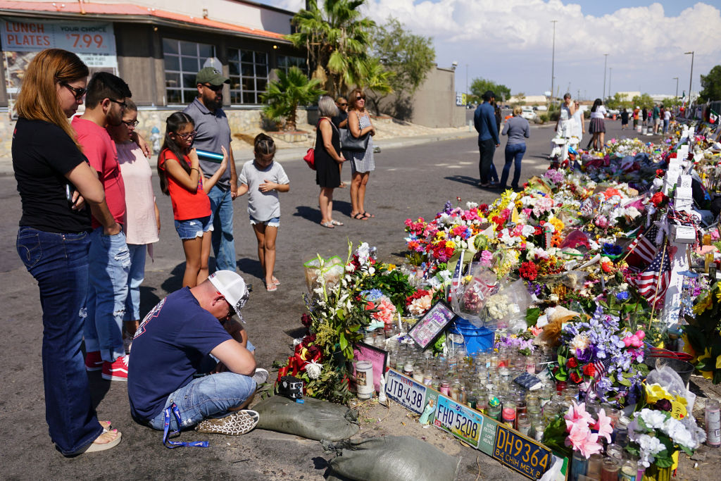 EL PASO, TX: People gather at a makeshift memorial to honor the 22 people who were killed in Walmart during a mass shooting along the U.S.-Mexico border. (Photo by Sandy Huffaker/Getty Images)