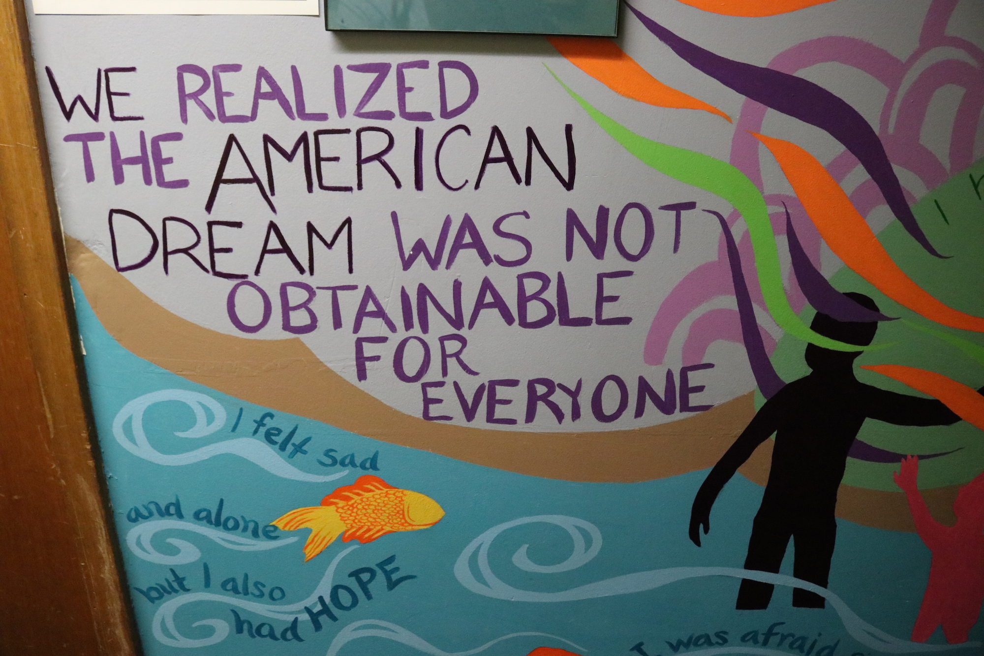 A wall in the Aquinas Center details the journey of immigrants to the U.S. Photo: Nigel Thompson/AL DÍA News.