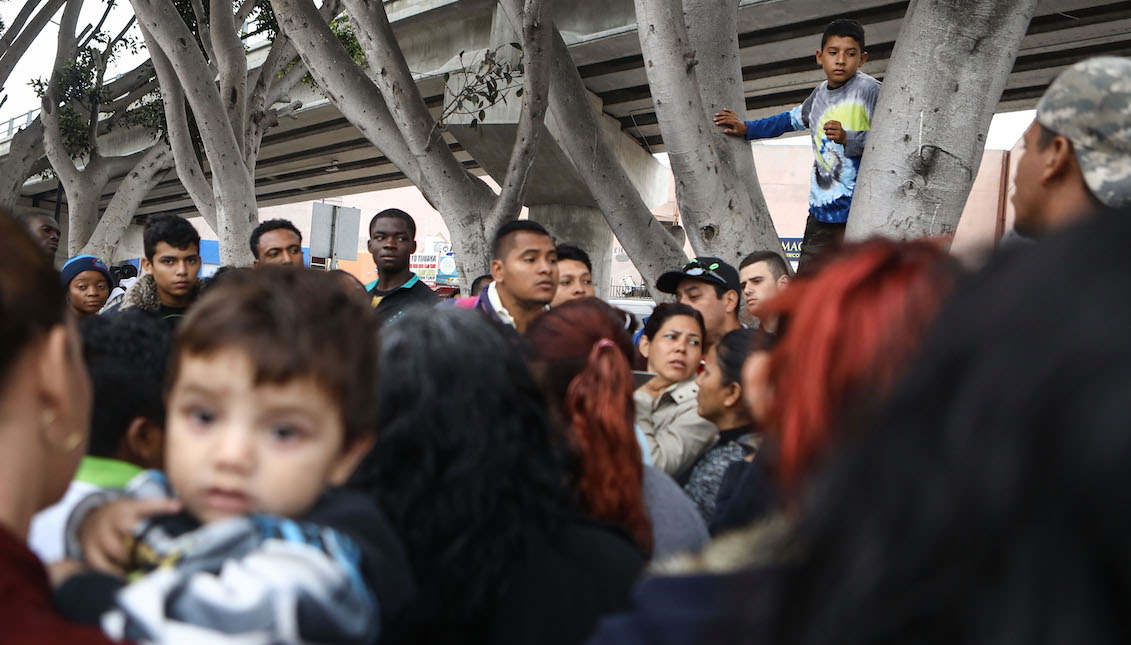 TIJUANA, MÉXICO - 20 DE JUNIO: Inmigrantes indocumentados se reúnen para escuchar información mientras esperan audiencias de asilo fuera del puerto de entrada el 20 de junio de 2018 en Tijuana, México. (Foto por Mario Tama/Getty Images)