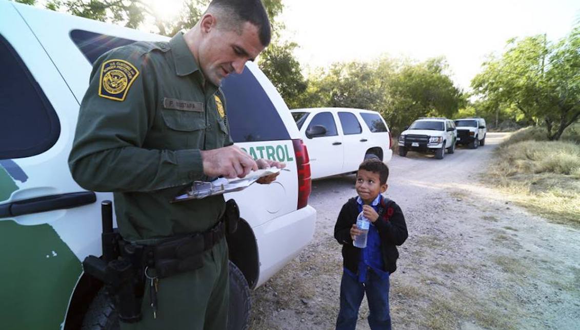 The Border Patrol and an immigrant child on the border. Photo: Jennifer Whitney / New York Times