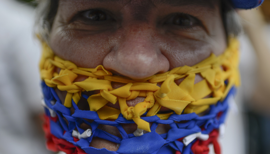 CARACAS, VENEZUELA - JULY 05: A Venezuelan wears ribbons of Venezuelan colors to cover her mouth as people gather at PNUD for a demonstration called by opposition leader Juan Guaido during the 208th anniversary of the Venezuelan Independence declaration on July 5, 2019 in Caracas, Venezuela. (Photo by Matias Delacroix/Getty Images)