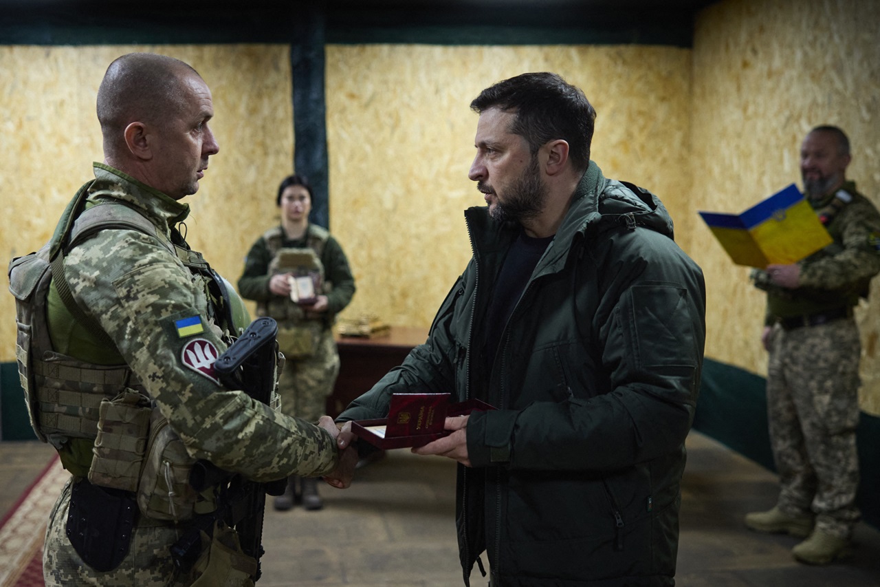 Esta fotografía tomada y difundida por el Servicio de Prensa Presidencial de Ucrania el 18 de noviembre de 2024 muestra al presidente de Ucrania, Volodymyr Zelensky (d), condecorando a un soldado ucraniano de la 14ª Brigada Mecanizada Separada en Kupyansk, región de Kharkiv, en medio de la invasión rusa de Ucrania. (Foto de Handout / SERVICIO DE PRENSA PRESIDENCIAL DE UCRANIA / AFP)