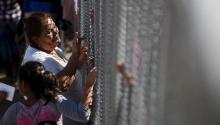 FILE PHOTO: A woman touches a family member through the border fence between Ciudad Juarez and El Paso, United States, after a bi-national Mass in support of migrants in Ciudad Juarez, Mexico, February 15, 2016. REUTERS/Jose Luis Gonzalez.